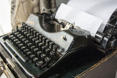 an image of a vintage typewriter with a blank sheet of paper in it